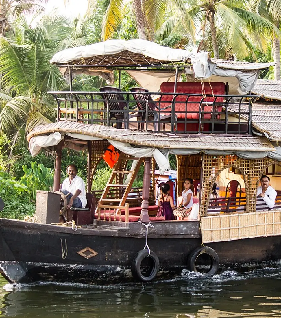People are travelling on a deluxe upper deck houseboat at Aleppey